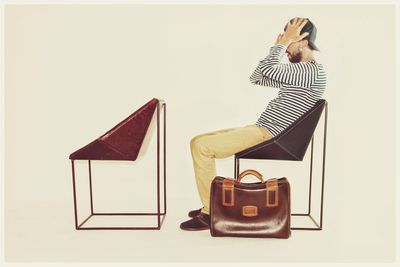 Rear view of man photographing against white background