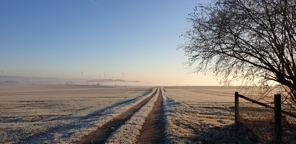 Scenic view of snow covered field against clear sky