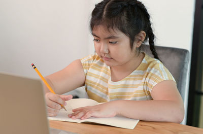 Asian girls are tutoring at home, study online at home, girls are bored and tired from studying.