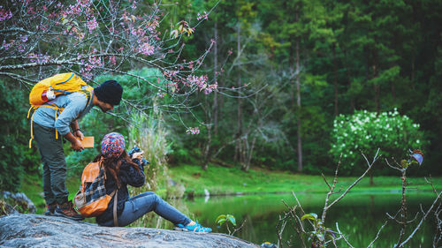 Couple by lake on rock at forest
