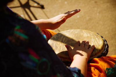 Cropped image of street musician playing drum on street