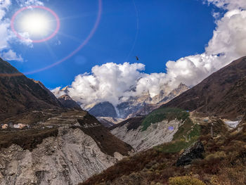 Low angle view of snowcapped mountains against blue sky