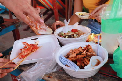 People holding food on table