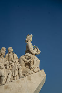 Low angle view of statue against clear blue sky