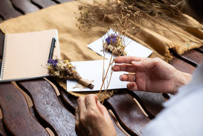 High angle view of women holding dried flower plant