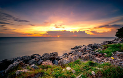Rocks on stone beach at sunset. beautiful landscape of calm sea. tropical sea at dusk. 