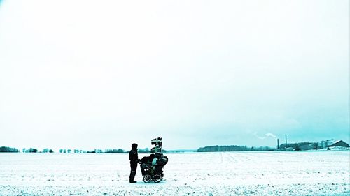 Men in sea against clear sky