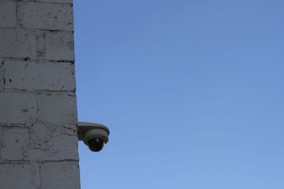 Low angle view of electric lamp against clear blue sky