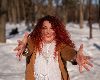 Portrait of young woman standing against trees