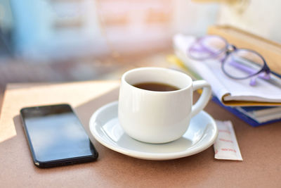 Close-up of coffee and mobile phone on table