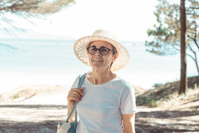 Portrait of young woman wearing hat standing on field