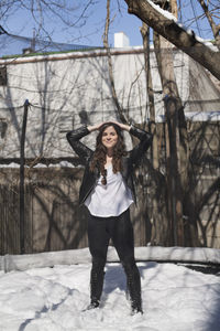 Happy young woman playing in the snow