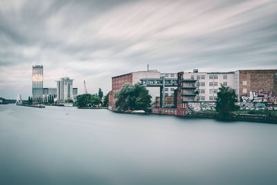 Buildings in city against cloudy sky