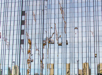 Reflection of cranes on office building