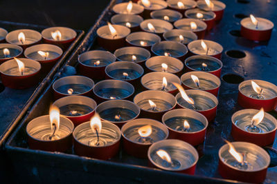 High angle view of lit tea light candles and flame