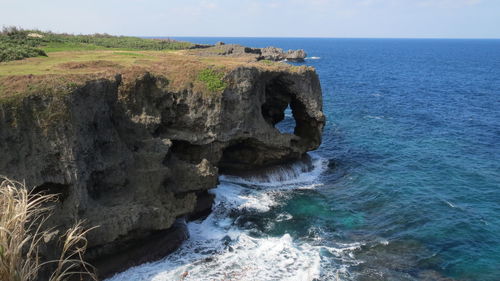 Rock formation on sea against sky