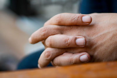 Cropped image of person with hands clasped