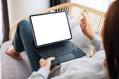 Midsection of woman using laptop at home