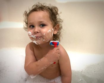 Portrait of shirtless boy in water at home