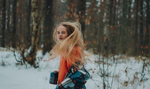 Side view of young woman standing in forest