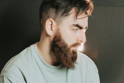 Close-up of man looking away against black background