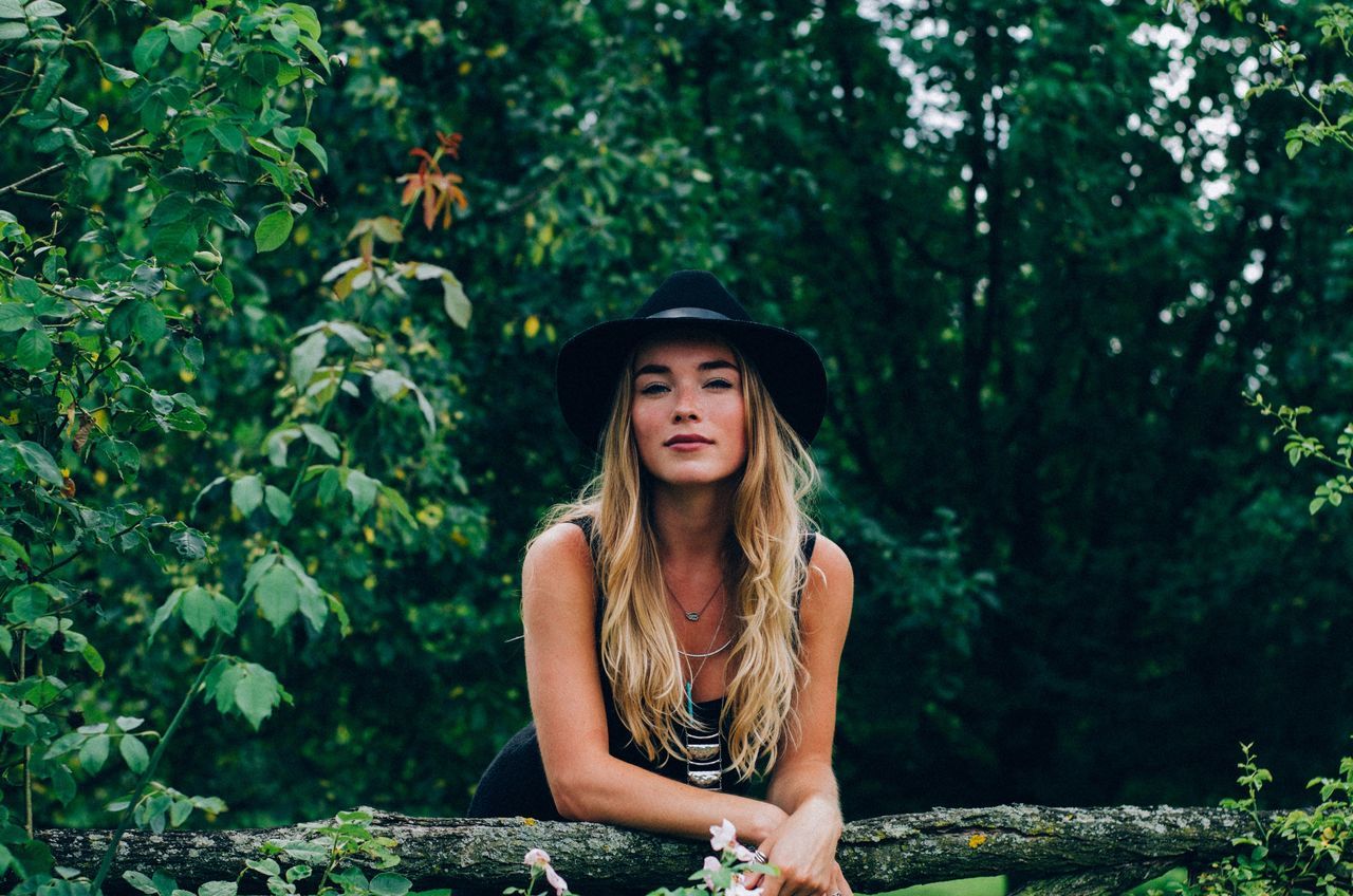 young adult, portrait, young women, looking at camera, person, front view, lifestyles, tree, casual clothing, standing, smiling, leisure activity, forest, long hair, three quarter length, waist up, happiness