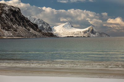 Scenic view of sea and mountains against sky