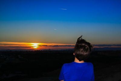 Rear view of woman looking at sunset