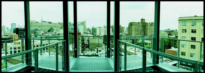 Panoramic view of city buildings seen through glass window