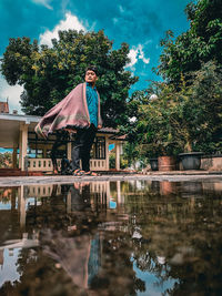 Man standing by lake against sky