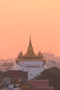 Temple building against sky during sunset