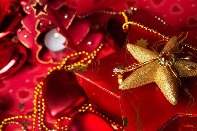 Close-up of christmas decoration on box over red background
