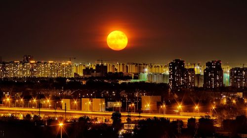 Super moon rising over the illuminated city at night, july 15, 2022
