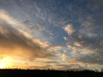 Scenic view of dramatic sky over field