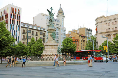 People on street against buildings in city