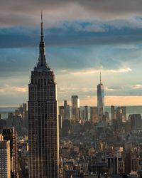 Buildings in city against cloudy sky