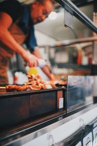 Man working on barbecue grill in kitchen