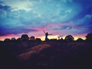 Silhouette of traditional windmill against sky at sunset