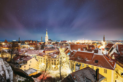 Illuminated cityscape against sky at night