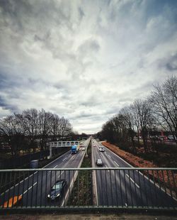 View of bridge in city against cloudy sky