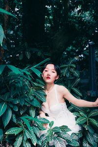 Young woman standing against tree