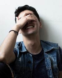 Close-up portrait of a young man against wall