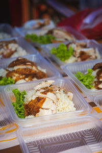  street stall or bazaar, chicken rice packed in bio degradable plastic container .