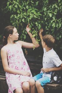 Mother and girl sitting on plant