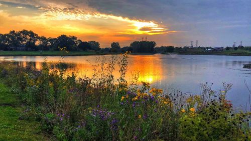 Scenic view of lake against sky at sunset
