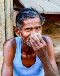 Portrait of man holding camera outdoors