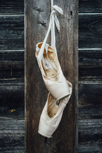 Ballet shoes hanging from wooden wall