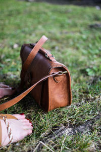 Close-up of leather bag on grass