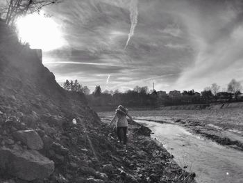 Full length of woman standing on hill against sky