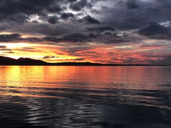 Scenic view of sea against dramatic sky during sunset